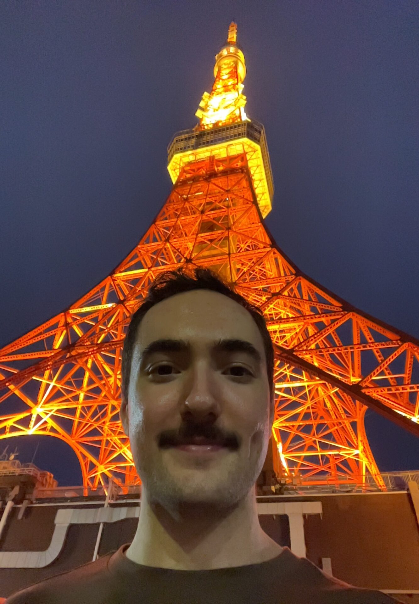 A very happy chap at the foot of a big tower in Tokyo